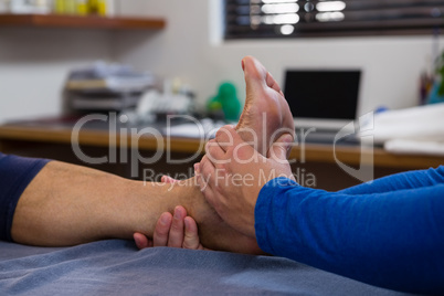Physiotherapist giving foot massage to female patient