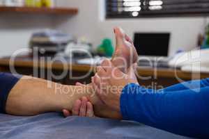 Physiotherapist giving foot massage to female patient