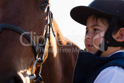 Rider boy caressing a horse in the ranch