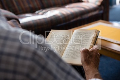 Hand of senior man reading book in nursing home