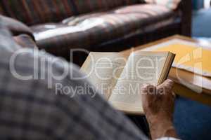 Hand of senior man reading book in nursing home