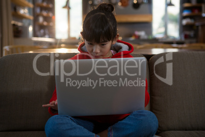 Girl using laptop on sofa