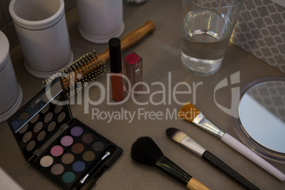 Beauty products with drinking glass on table