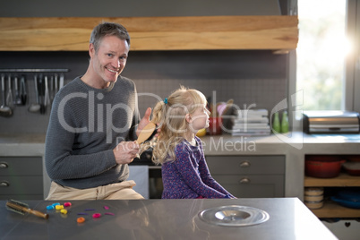 Daughter brushing fathers hair