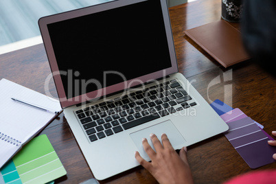 Cropped hand of woman using laptop