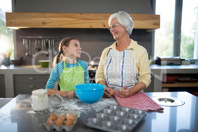 Smiling grandmother and granddaughter looking at each other