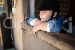 Girl leaning on wall in the stable