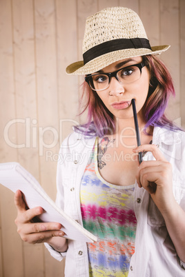 Thoughtful woman holding notepad and pen
