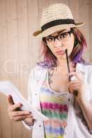Thoughtful woman holding notepad and pen