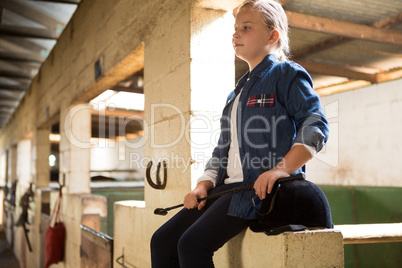 Girl sitting in stable