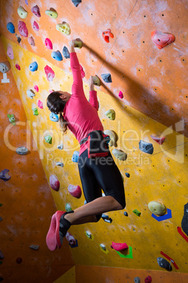 Determined woman practicing rock climbing