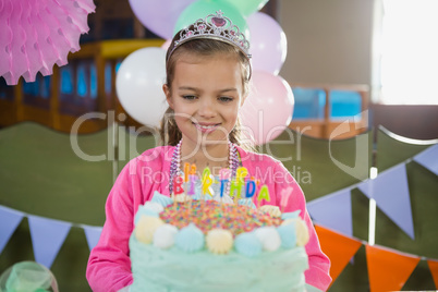 Birthday girl looking at cake