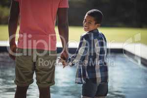 Father and son standing near poolside