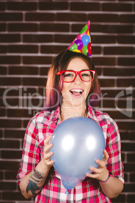 Beautiful woman in party hat against brick wall