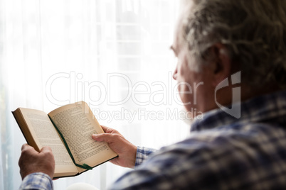 Close up senior man reading book in nursing home