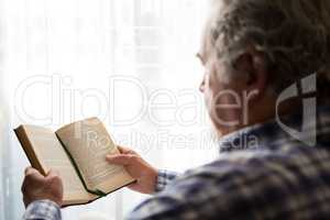 Close up senior man reading book in nursing home