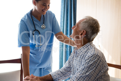 Female doctor consoling senior man in nursing home