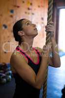 Woman preparing for rope climbing in fitness studio