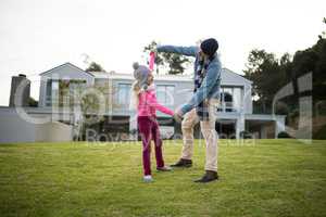 Father and daughter dancing in garden