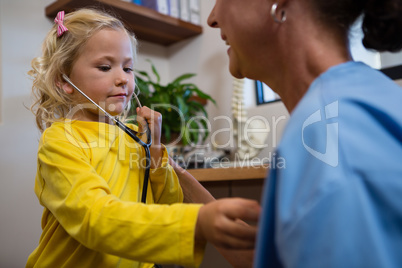 Little girl using stethoscope in hospital