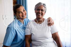 Portrait of young nurse with patient in nursing home
