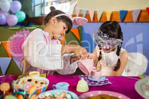 Kids playing with tea set during birthday party