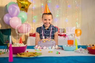 Girl standing with birthday cake at home