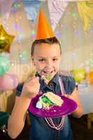 Girl eating cake during birthday party at home