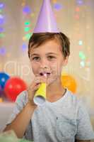 Boy blowing a party horn during birthday party