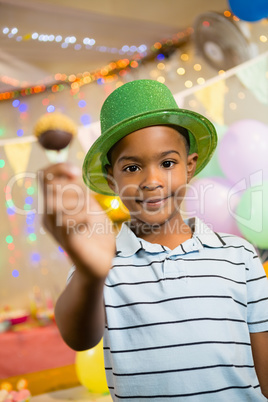 Portrait of happy boy holding lollipop during birthday party