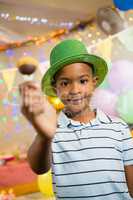 Portrait of happy boy holding lollipop during birthday party