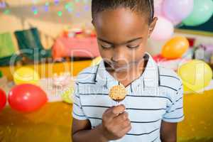 Cute boy holding lollipop during birthday party