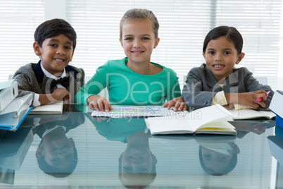 Portrait of smiling kids discussing in boardroom