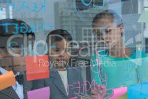 Colleagues discussing while writing on glass