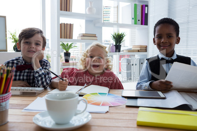 Portrait of business people working at table in creative office