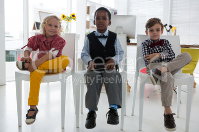 Portrait of business people relaxing on chair in office