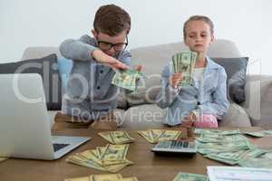 Business people counting currency while sitting on sofa