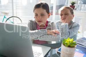 Female colleagues discussing over laptop at desk