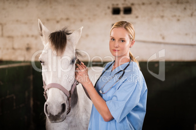 Portrait of confident vet standing by horse