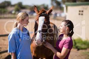 Female vet and woman looking at horse