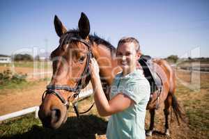 Portrait of female jockey fastening bridle