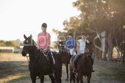 Portrait of women with trainer riding horse