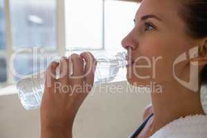 Close up of female athlete drinking water in gym