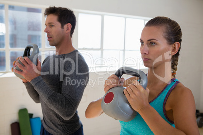 Athletes exercising with kettlebells in gym