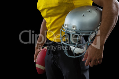 American football player holding a ball and head gear