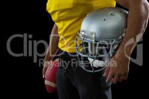 American football player holding a ball and head gear
