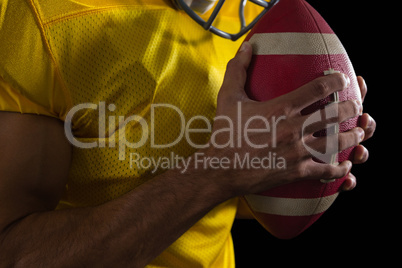 American football player holding a ball with both his hands