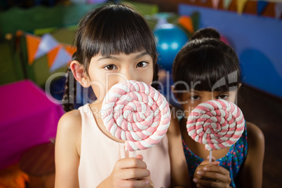 Kids holding a lollipop during birthday party at home