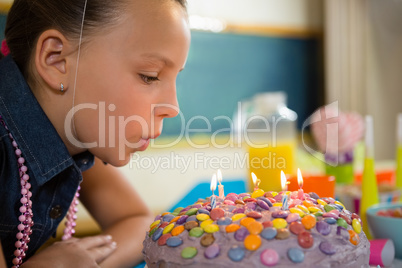 Girl blowing out the candles on a birthday cake