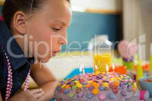 Girl blowing out the candles on a birthday cake